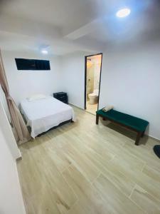 a bedroom with a bed and a bench in a room at Hotel el Trebol in Rivera