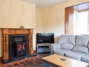 sala de estar con sofá y chimenea en Llantysilio Lodge, en Llangollen