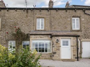 a brick house with a white door and windows at Rooftops - Uk34065 in Grassington