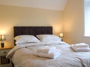 1 dormitorio con 1 cama grande y toallas. en Llantysilio Lodge, en Llangollen