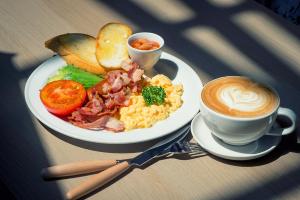 a plate of breakfast food and a cup of coffee at Into the town krabi in Krabi