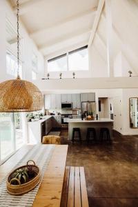 プリンスビルにあるBOHO New Construction: On Golf Course/views/Hot tub AC walk to market and beachの白い大型キッチン(テーブル付)