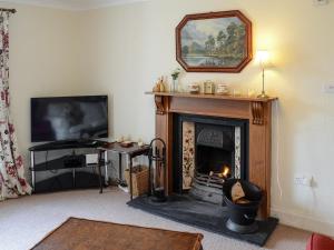 a living room with a fireplace and a television at An Sealladh in Lochinver
