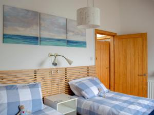 a bedroom with two beds and a lamp at Seascape in Fiskavaig
