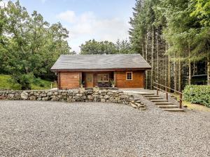 Cette cabane en rondins est dotée d'un mur en pierre. dans l'établissement Larch, à Killin