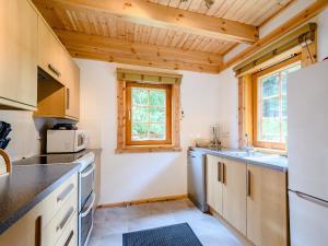 a kitchen with wooden ceilings and a white refrigerator at Larch in Killin