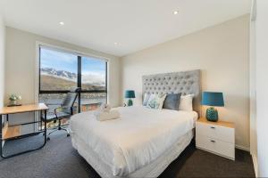 a bedroom with a bed and a desk and a window at Queenstown Lake and Mountain View Retreat Free Wifi Free Street Parking in Queenstown