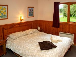 a bedroom with a bed with a towel on it at Treetops Lodge - Uk30556 in Urchany