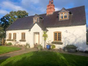 a white house with a black roof at Waen Farm Cottage in Tremeirchion