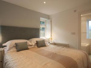 ein Schlafzimmer mit einem großen Bett mit zwei Kissen in der Unterkunft Tintern Abbey Cottage in Tintern