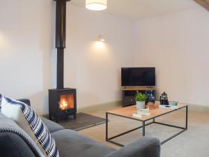 a living room with a couch and a fireplace at The Dairy - Uk34564 in Whitchurch