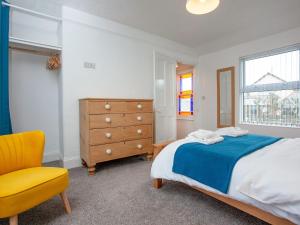 Park View في هارتلاند: غرفة نوم بسرير وخزانة وكرسي اصفر