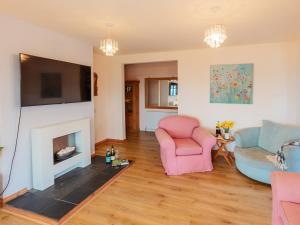 a living room with two chairs and a fireplace at Wagtails in Milverton