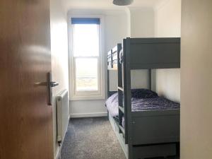 a bedroom with two bunk beds and a window at East Apartment in Lowestoft