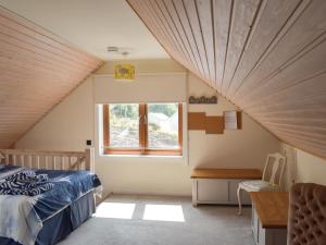 a attic bedroom with a bed and a window at Seal Rocks in Lendalfoot