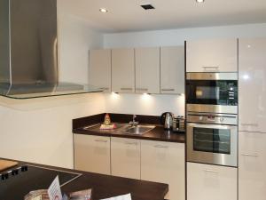 een keuken met witte kasten en een wastafel bij North Bay Sands Apartment 1-uk2629 in Scarborough
