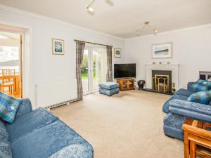 a living room with two blue couches and a tv at Taigh Na Beadan in Valtos