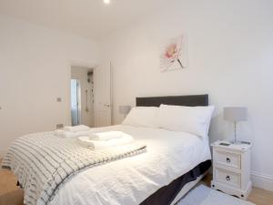a bedroom with a large bed with a white bedspread at Water View in Looe