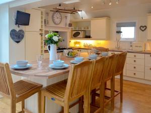 a kitchen with a wooden table with chairs and a dining room at Maggies Den in Gatehouse of Fleet
