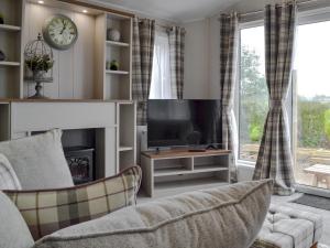 a living room with a tv and a couch at Pheasant - Uk31514 in Calthwaite