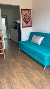 ein blaues Sofa im Wohnzimmer mit Holzboden in der Unterkunft Verano Azul Loft in Puerto López