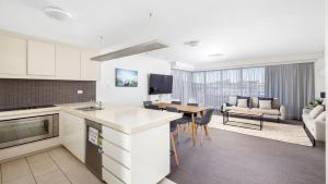 a kitchen and living room with a table and a couch at Cote D'Azur Resort in Nelson Bay