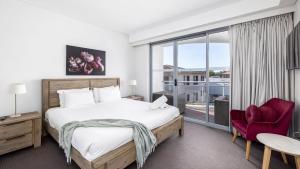 a bedroom with a bed and a large window at Cote D'Azur Resort in Nelson Bay