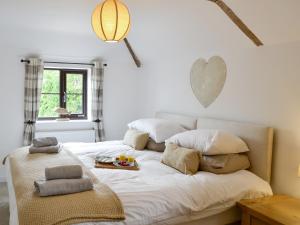 a white bed with a tray of food on it at Riverbank Cottage in Reedham