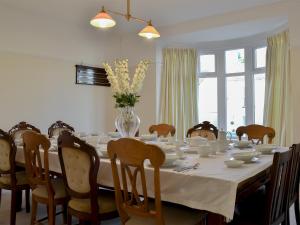 a dining room table with a vase of flowers on it at Littlewood in Saint Columb Major