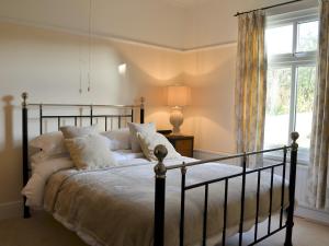 a bedroom with a bed and a window at Littlewood in Saint Columb Major