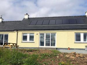 a house with solar panels on the roof at Caroy Bay Cottage-uk32669 in Harlosh