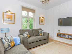 a living room with a couch and a tv at Station House in Millers Dale