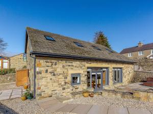 een stenen huis met een patio ervoor bij Penthwaite in Leyburn