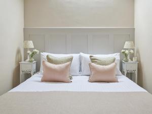 a white bed with two pink pillows on it at Farndale in Pickering