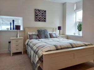 a bedroom with a bed and two lamps and a window at Rathven Parish Church Hall in Portessie