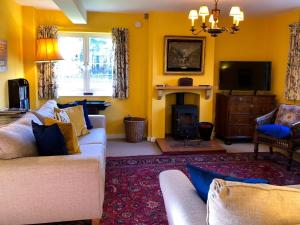 a living room with a couch and a fire place at Orchard House in Baconsthorpe