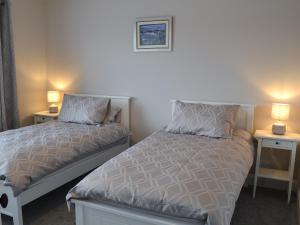 a bedroom with two beds and two lamps on tables at Seaholme in Seahouses