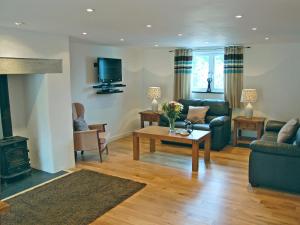 a living room with a couch and a table at Home Park Farm Cottages B in Lanteglos