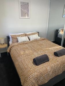 a bedroom with a bed with two pillows on it at Central Cronulla Apartment Nestled in the Treetops in Cronulla