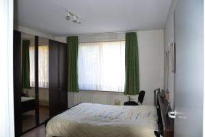1 dormitorio con cama y ventana grande en Lindehof Serviced Flats, en Zoersel