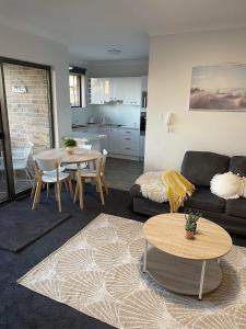 a living room with a couch and a table at Central Cronulla Apartment Nestled in the Treetops in Cronulla