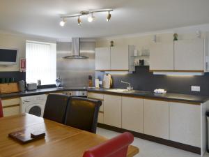 a kitchen with a wooden table and a dining room at Seabreezes - Uk30690 in Portknockie