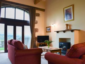 a living room with two chairs and a fireplace at Stable Cottage - Ifu in Airton