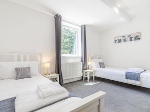 1 dormitorio con 2 camas y ventana en High Trees View, en Knaresborough