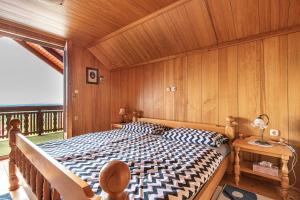 a bedroom with a bed with a wooden wall at Pool Villa Adonis - Happy Rentals in Semič