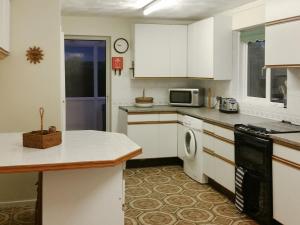 a kitchen with white cabinets and a washer at Dinsel in Upton