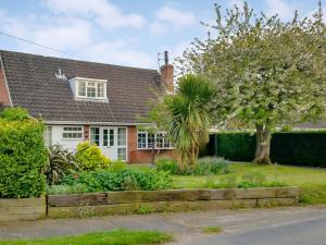 a house with a palm tree in the yard at Dinsel in Upton