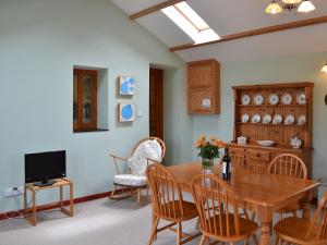 a dining room with a table and chairs and a tv at Cowslip - Uk12060 in Lower Boscaswell