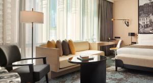 a hotel room with a couch and a bed at Hotel Stripes Kuala Lumpur, Autograph Collection in Kuala Lumpur