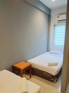 a small room with two beds and a table at Bukit Bentong Homestay in Bentong